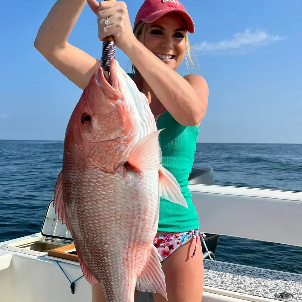 Angler posing with a red snapper caught on a Pensacola Beach fishing charter